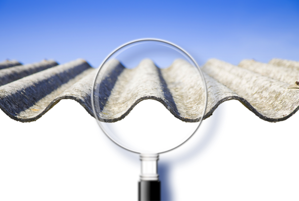 Magnifying glass against a sheet of zinc with asbestos
