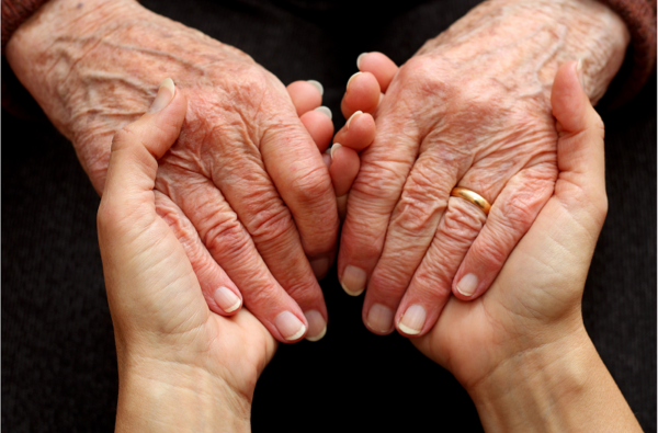 elderly person's hands in younger person's hands